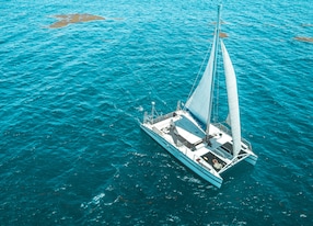 catamaran sailing in clear ocean water