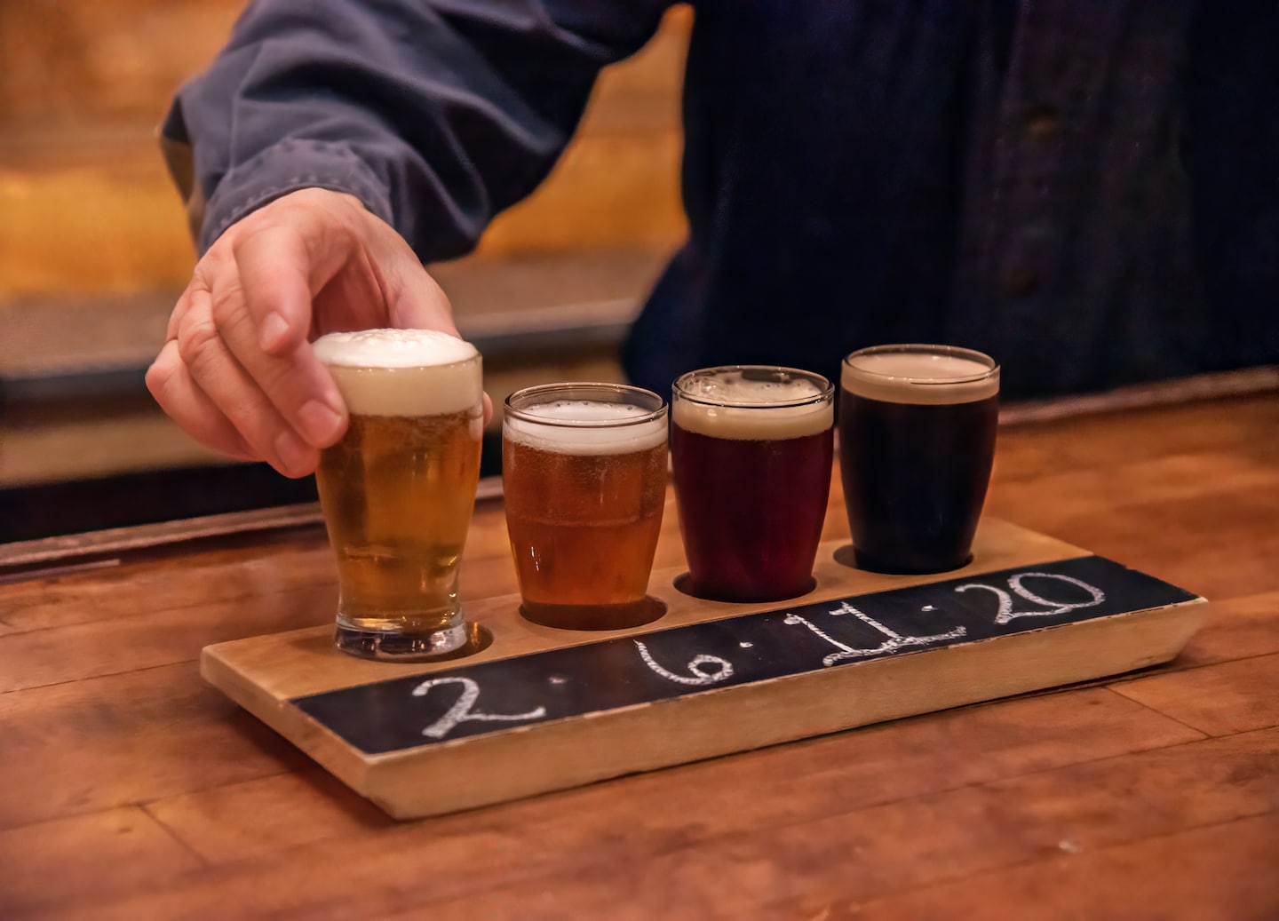 A tasting flight of local Portland beers sits arranged on a wooden board along the waterfront. - Portland, Maine