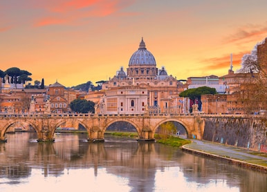 cityscape and panoramic view of old bridge with warm sunset sky water reflections and dome of st