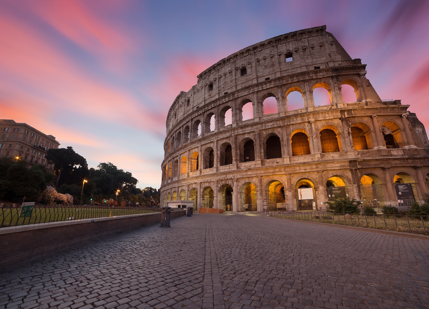 Sunlit Colosseum arches rise above ancient stone arena in central Rome. - Rome, Italy