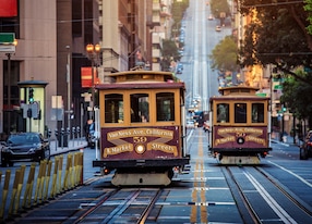 classic view of historic traditional cable cars riding on famous california street in morning light