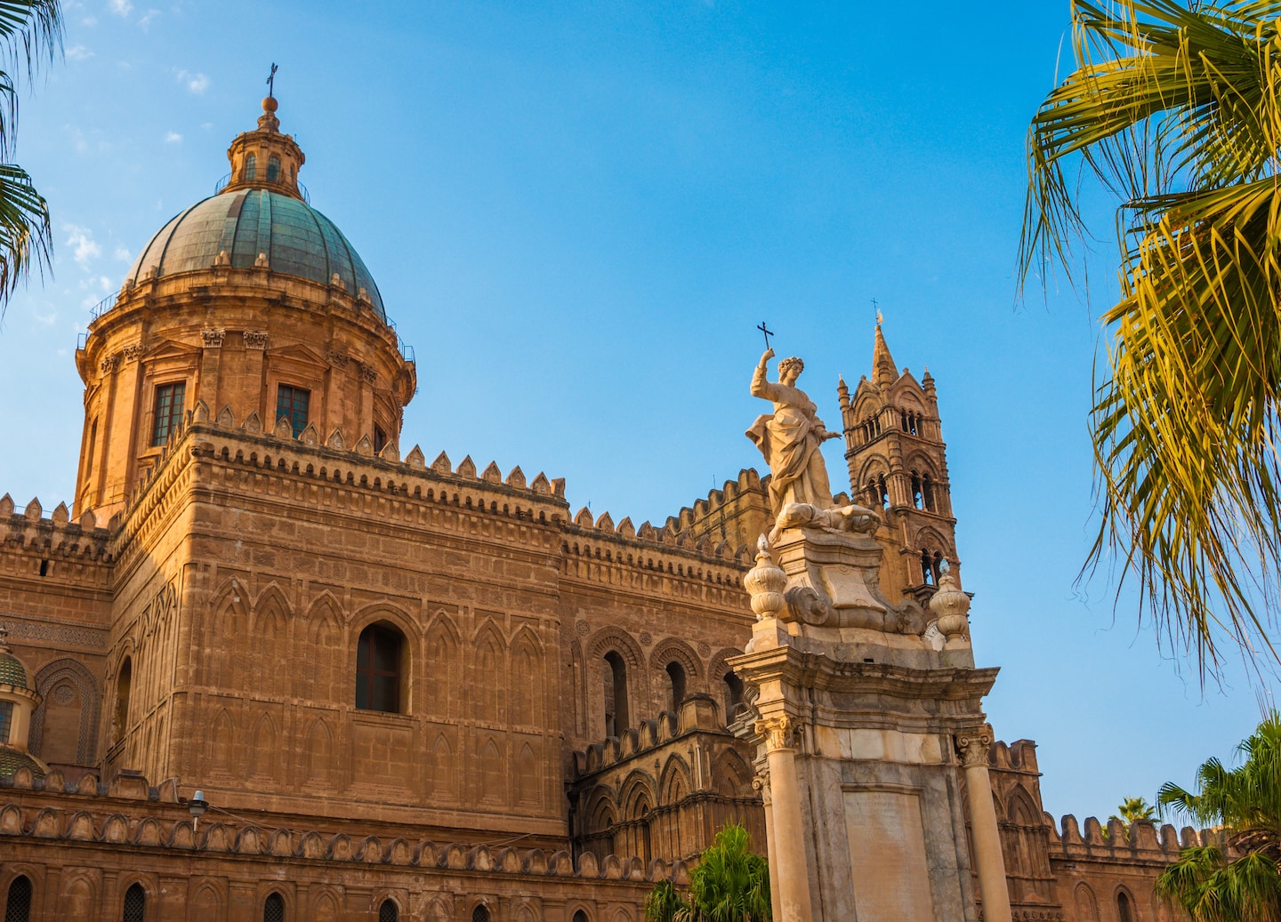 Palermo Cathedral glows at sunset, its ornate arches and domes highlighted against the Sicilian sky. - Palermo, Italy
