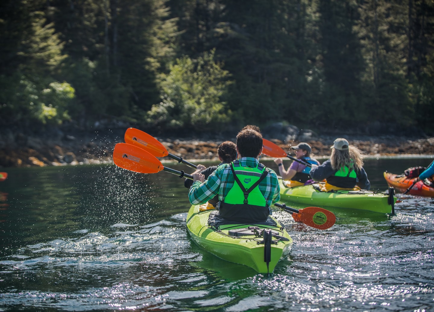 Group kayaks glide across calm Sitka Sound. - Sitka, Alaska