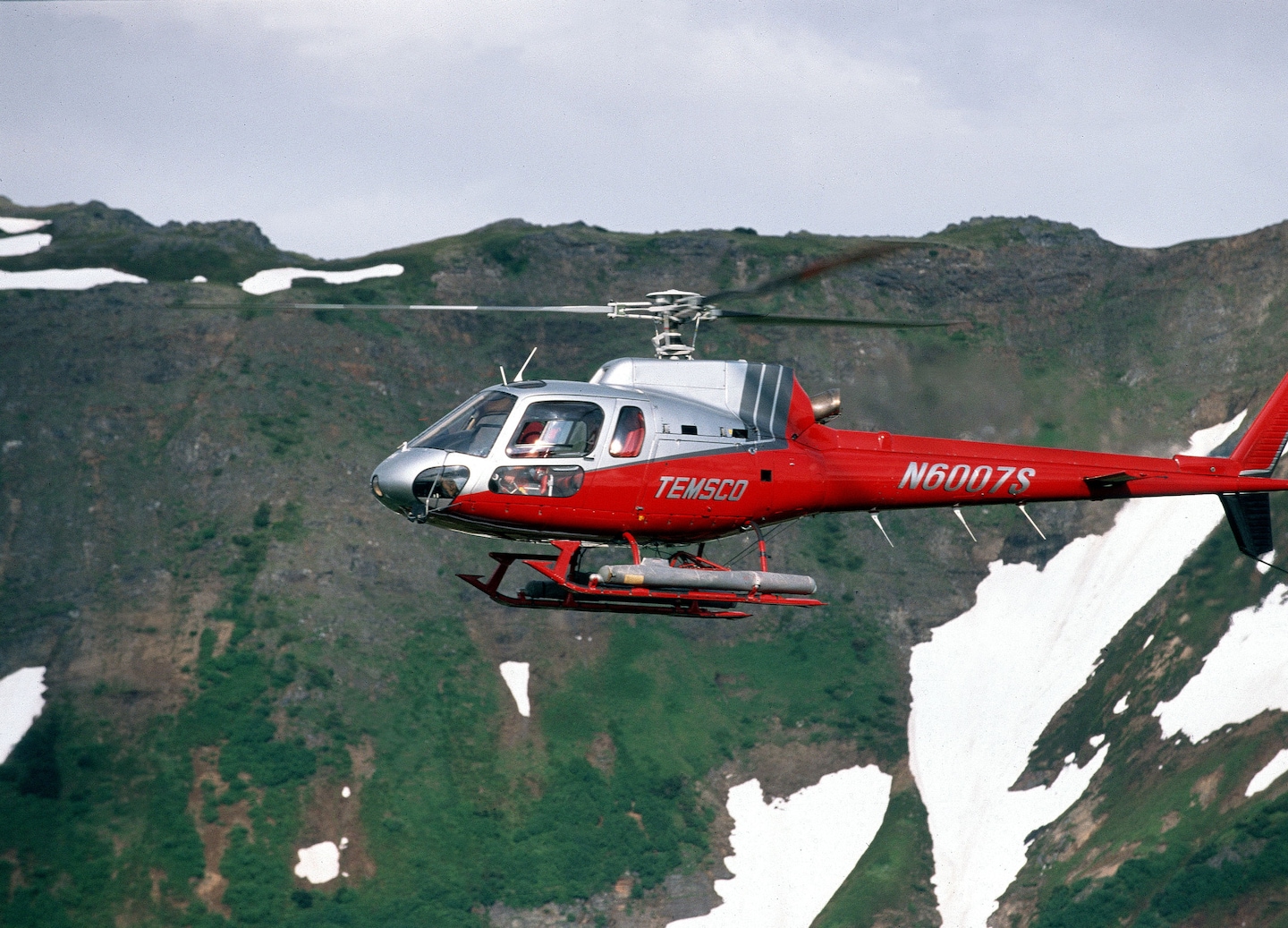 Helicopter soars above rugged Skagway peaks. - Skagway, Alaska