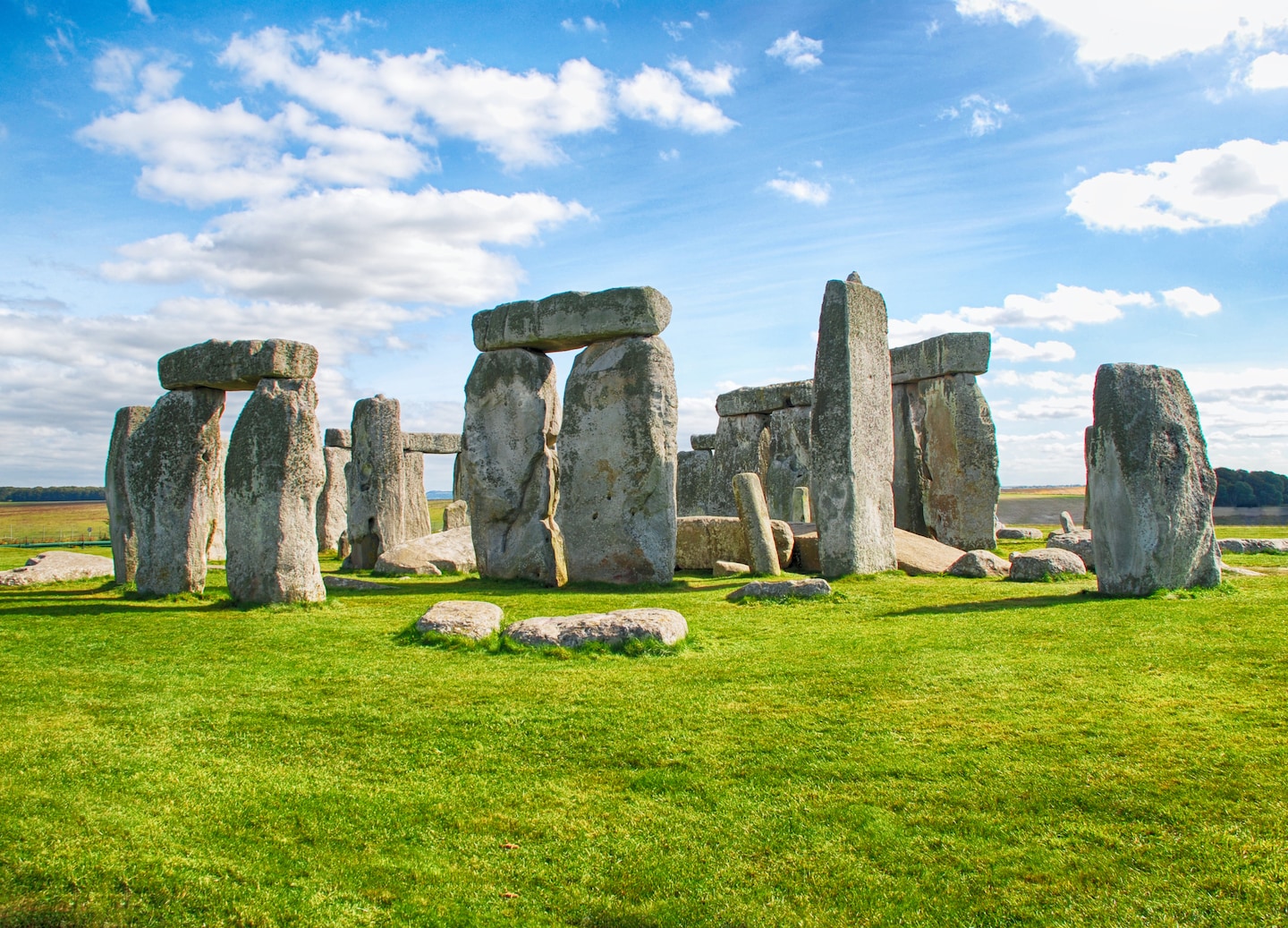 Ancient Stonehenge stands beneath bright blue sky on open grassland. - Southampton, England