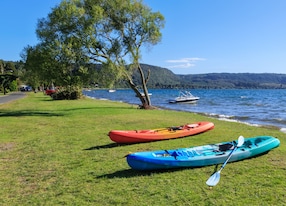 kayaks on the grassy shore of lake rotoiti new zealand