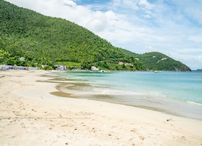 white sand beach shoreline mountain
