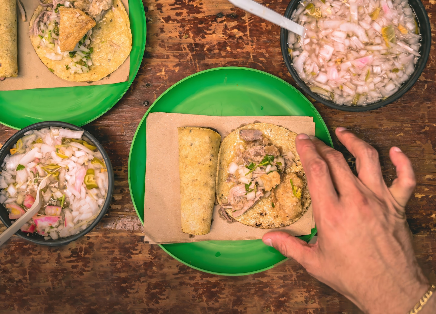 Taco filled with seasoned meat, topped with fresh vegetables served on a green plate. - Yucatan, Mexico